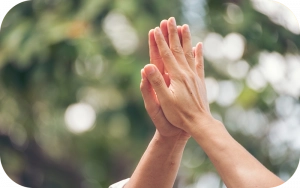 Zwei Hände treffen sich zu einem High-Five vor verschwommenem grünem Hintergrund – Symbol für Zusammenarbeit, Erfolg und gemeinsames Wachstum im Affiliate-Programm.